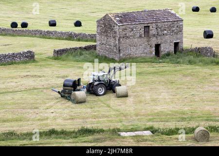 Sommerhaymaking, Hawes, Wensleydale, North Yorkshire. Rundballen sind mit Kunststoff umwickelt, um Luft auszuschließen und Silage oder Heulage für Winterfutter zu machen. Stockfoto