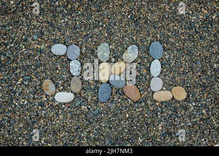 Buchstaben j k l aus Steinen im Sand am Strand Stockfoto