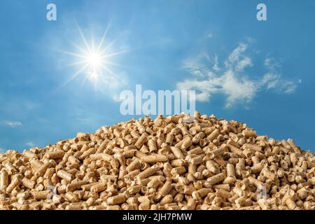 Haufen Holzpellets gegen blauen Himmel. Komprimiertes Sägemehl-Granulat als alternative Energie für die Heizenergie. Ökologischer Biokraftstoff aus verdichtetem Sägemehl. Stockfoto