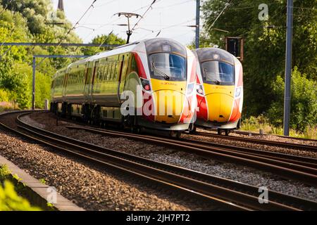 Zwei Diesel-Hybrid-Züge der London North Eastern Railways „Azuma“ fahren auf der East Coast Main Line in Offord Cluny, Cambridgeshire, E, aneinander vorbei Stockfoto