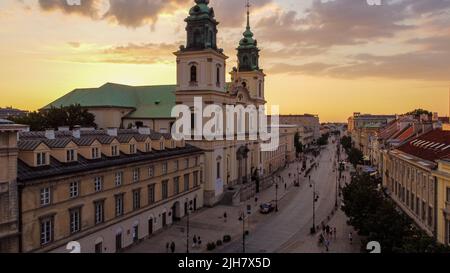 Holy Cross Church und Krakowskie Przedmieście bei Sonnenuntergang, Warschau, Polen Stockfoto