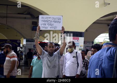 16. Juli 2022, Dhaka, Dhaka, Bangladesch: Mohiuddin Roni, Eine Studentin der Dhaka University ist seit 10 Tagen im Bahnhof Kamalapur in Dhaka, um gegen die schwarze Vermarktung von Bahntickets und das allgemeine Missmanagement zu protestieren. Während Eid UL-Adha, auf dem Rückweg nach Hause, buchte er das Zugticket über das Internet, konnte aber wegen des Schwarzmarktproblems mit dem Ticket nicht reisen. Dann nahm er einen Proteststand auf dem Bahnhof und begann, durch darstellende Künste zu protestieren. Er selbst hat seine Hände angekettet. Er stellte 6-Punkte-Forderungen vor und kündigte an, sein Sit-in-Programm so lange fortzusetzen, bis es soweit ist Stockfoto