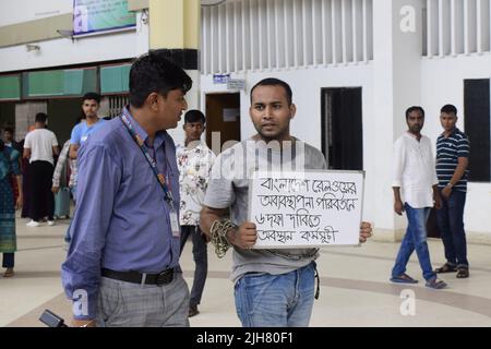 16. Juli 2022, Dhaka, Dhaka, Bangladesch: Mohiuddin Roni, Eine Studentin der Dhaka University ist seit 10 Tagen im Bahnhof Kamalapur in Dhaka, um gegen die schwarze Vermarktung von Bahntickets und das allgemeine Missmanagement zu protestieren. Während Eid UL-Adha, auf dem Rückweg nach Hause, buchte er das Zugticket über das Internet, konnte aber wegen des Schwarzmarktproblems mit dem Ticket nicht reisen. Dann nahm er einen Proteststand auf dem Bahnhof und begann, durch darstellende Künste zu protestieren. Er selbst hat seine Hände angekettet. Er stellte 6-Punkte-Forderungen vor und kündigte an, sein Sit-in-Programm so lange fortzusetzen, bis es soweit ist Stockfoto