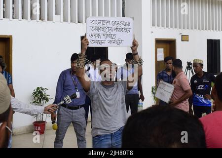 16. Juli 2022, Dhaka, Dhaka, Bangladesch: Mohiuddin Roni, Eine Studentin der Dhaka University ist seit 10 Tagen im Bahnhof Kamalapur in Dhaka, um gegen die schwarze Vermarktung von Bahntickets und das allgemeine Missmanagement zu protestieren. Während Eid UL-Adha, auf dem Rückweg nach Hause, buchte er das Zugticket über das Internet, konnte aber wegen des Schwarzmarktproblems mit dem Ticket nicht reisen. Dann nahm er einen Proteststand auf dem Bahnhof und begann, durch darstellende Künste zu protestieren. Er selbst hat seine Hände angekettet. Er stellte 6-Punkte-Forderungen vor und kündigte an, sein Sit-in-Programm so lange fortzusetzen, bis es soweit ist Stockfoto