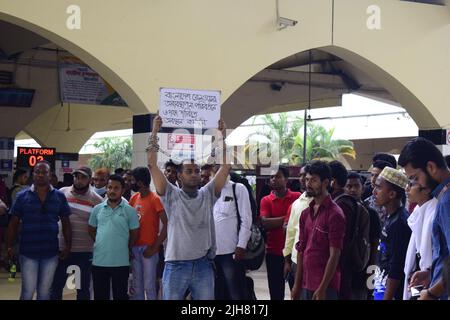 16. Juli 2022, Dhaka, Dhaka, Bangladesch: Mohiuddin Roni, Eine Studentin der Dhaka University ist seit 10 Tagen im Bahnhof Kamalapur in Dhaka, um gegen die schwarze Vermarktung von Bahntickets und das allgemeine Missmanagement zu protestieren. Während Eid UL-Adha, auf dem Rückweg nach Hause, buchte er das Zugticket über das Internet, konnte aber wegen des Schwarzmarktproblems mit dem Ticket nicht reisen. Dann nahm er einen Proteststand auf dem Bahnhof und begann, durch darstellende Künste zu protestieren. Er selbst hat seine Hände angekettet. Er stellte 6-Punkte-Forderungen vor und kündigte an, sein Sit-in-Programm so lange fortzusetzen, bis es soweit ist Stockfoto