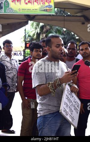 16. Juli 2022, Dhaka, Dhaka, Bangladesch: Mohiuddin Roni, Eine Studentin der Dhaka University ist seit 10 Tagen im Bahnhof Kamalapur in Dhaka, um gegen die schwarze Vermarktung von Bahntickets und das allgemeine Missmanagement zu protestieren. Während Eid UL-Adha, auf dem Rückweg nach Hause, buchte er das Zugticket über das Internet, konnte aber wegen des Schwarzmarktproblems mit dem Ticket nicht reisen. Dann nahm er einen Proteststand auf dem Bahnhof und begann, durch darstellende Künste zu protestieren. Er selbst hat seine Hände angekettet. Er stellte 6-Punkte-Forderungen vor und kündigte an, sein Sit-in-Programm so lange fortzusetzen, bis es soweit ist Stockfoto