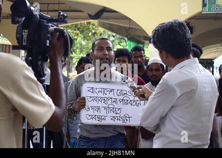 16. Juli 2022, Dhaka, Dhaka, Bangladesch: Mohiuddin Roni, Eine Studentin der Dhaka University ist seit 10 Tagen im Bahnhof Kamalapur in Dhaka, um gegen die schwarze Vermarktung von Bahntickets und das allgemeine Missmanagement zu protestieren. Während Eid UL-Adha, auf dem Rückweg nach Hause, buchte er das Zugticket über das Internet, konnte aber wegen des Schwarzmarktproblems mit dem Ticket nicht reisen. Dann nahm er einen Proteststand auf dem Bahnhof und begann, durch darstellende Künste zu protestieren. Er selbst hat seine Hände angekettet. Er stellte 6-Punkte-Forderungen vor und kündigte an, sein Sit-in-Programm so lange fortzusetzen, bis es soweit ist Stockfoto