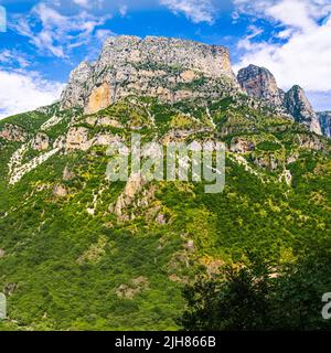 Türme von Astraka, die die Vikos-Schlucht oberhalb der Voidomatis-Quellen in Zagori-Nordgriechenland dominieren 1300m - 4260ft von der Klippe zum Fluss (links unten) Stockfoto