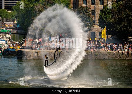 Auf dem Wasser findet eine waghalsige Flyboarding-Akrobatik-Schau statt und zieht beim Bristol Harbour Festival in Bristol riesige Menschenmengen an. Bilddatum: Samstag, 16. Juli 2022. Stockfoto