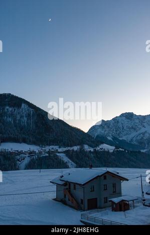 Eine vertikale Aufnahme eines kleinen Hauses in den verschneiten Bergen von Schilpario, Italien Stockfoto