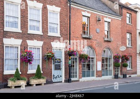 Hängeaufbewahrung mit Blumen auf Hausfassaden in der Stadt Bilovec, Worcestershire, UK Stockfoto