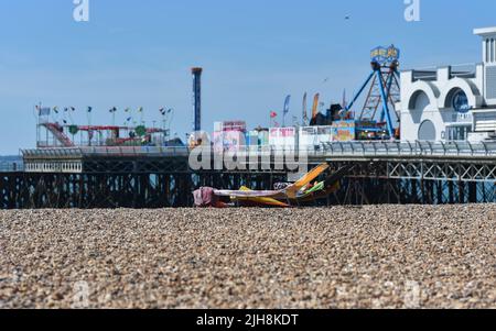 Sonnenliegen am Southsea Beach in Portsmouth, England vor dem South Parade Pier an einem heißen Sommertag Stockfoto