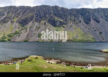 Paddlebarder am Wastwater Lake werden von den massiven Geröllhängen von Illgill Head Wasdale Cumbria England in den Schatten gestellt Stockfoto