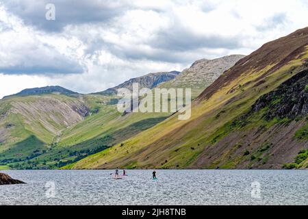 Paddelboarder am Wastwater Lake mit den dramatischen Geröllhängen im Hintergrund, an einem Sommertag Wasdale, Cumbria England Stockfoto