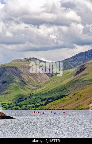 Kanufahrer am Waster Lake, an einem Sommertag, mit der dramatischen zerklüfteten Landschaft im Hintergrund Wasdale Cumbria England Stockfoto