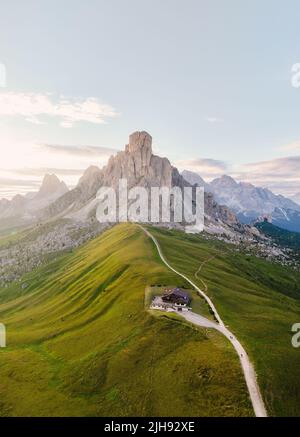 Blick von oben, atemberaubende Luftaufnahme des Giau-Passes bei einem wunderschönen Sonnenuntergang. Der Giau Pass ist ein Hochgebirgspass in den Dolomiten. Stockfoto