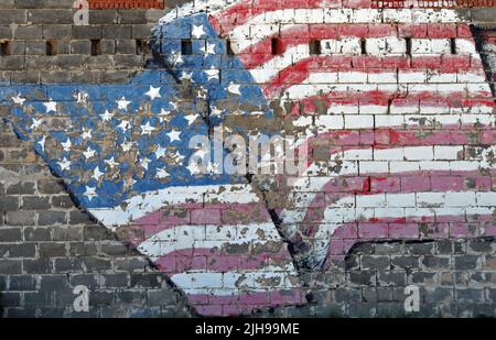 Ein gemaltes Wandgemälde mit amerikanischer Flagge schmückt die Backsteinmauer eines Gebäudes in der Stadt Route 66 in Erick, Oklahoma. Stockfoto