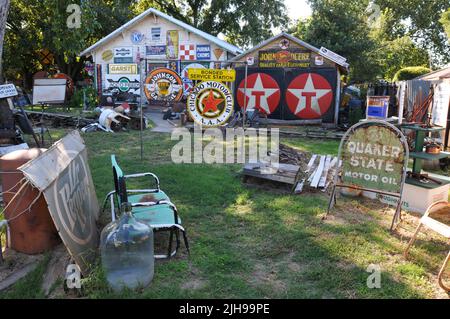 Auf dem Hof des Sandhills Curriciity Shop, einer Route 66-Attraktion in Erick, Oklahoma, sind alte Werbeschilder ausgestellt. Stockfoto