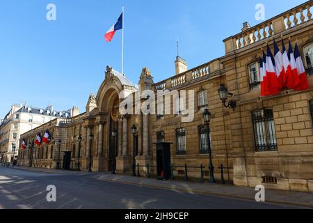 Blick auf das Eingangstor des Elysee-Palastes mit Nationalflaggen. Elysee Palace - offizielle Residenz des Präsidenten der Französischen Republik seit Stockfoto