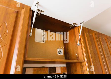 Ein Platz für die Installation einer Küchenhaube, Renovierung in einem neuen Haus, ein Loch mit Steckdosendrähten. Stockfoto