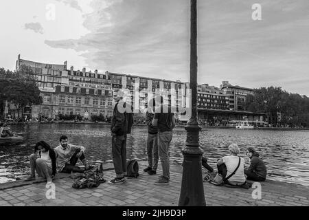 05-06-2016 Paris, Frankreich. Unternehmen von jungen Menschen auf der Bank von Le Bassin de la Villette Stockfoto