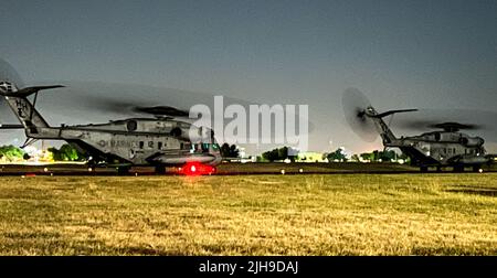 Zwei Marine CH-53 Sea Hengst-Hubschrauber taxen auf dem Henry Post Army Airfield-Rollweg, um von einem Marine KC-130J am 12. Juli 2022 zu tanken. Stockfoto