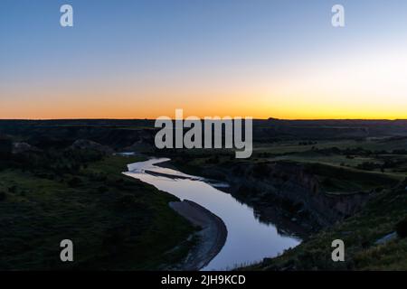 Die Sonne geht über dem Missouri River im Theodore Roosevelt National Park in North Dakota unter Stockfoto