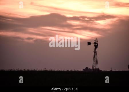 Windmühle bei Sonnenuntergang in der argentinischen Landschaft, Provinz Pampas, Patagonien, Argentinien. Stockfoto