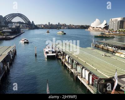 Sydneys Circular Quay führt 6, 5 & 4 an der Sydney Cove mit Hafenfähren, der Harbour Bridge und dem Opernhaus im Hintergrund. Stockfoto