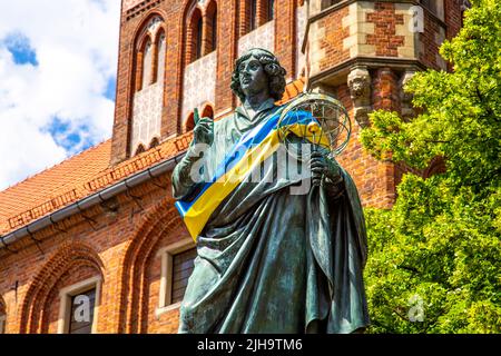 Denkmal von Nicolaus Copernicus mit einem Astrolabium mit ukrainischer Flagge in Toruń, Polen Stockfoto