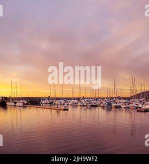 Malerische Aussicht auf private Yachten, die bei Sonnenuntergang in Bodo, Norwegen, im Wasserhafen angedockt sind. Nautische Transportschiffe und Boote in einer Werft am Morgen um Stockfoto