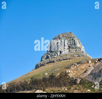 Landschaft von Lions Head Berg auf einem klaren blauen Himmel mit Kopierraum. Rocky Berggipfel mit sanften Hügeln mit Gras Bäume und Sträucher in der Nähe bedeckt Stockfoto