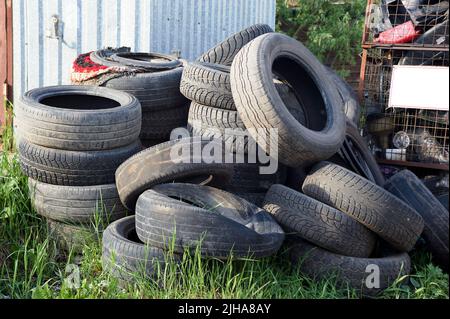 Ein Haufen alter Autoreifen liegt im Gras Stockfoto