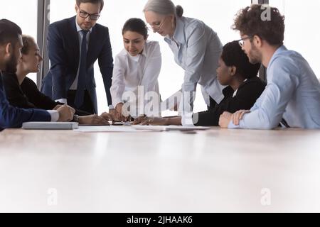 Multiethnische Marketinggruppe mit unterschiedlichen Alters, die Papierberichte diskutiert Stockfoto