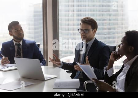 Selbstbewusster kaukasischer Geschäftsmann, Teamleiter spricht bei einem Unternehmensmeeting Stockfoto