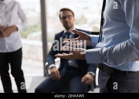 Geste eines männlichen Geschäftsführers, der mit den Mitarbeitern spricht Stockfoto