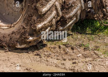 Schmutzige Doppelräder der Landwirtschaft Traktor auf Feldweg an sonnigen Sommertag Stockfoto