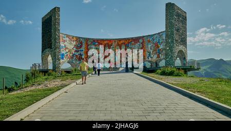 Russland-Georgien-Freundschaftsdenkmal in Gudauri, Georgien Außenansicht von Tageslicht mit wandelenden Besuchern und Wolken am Himmel im Hintergrund Stockfoto