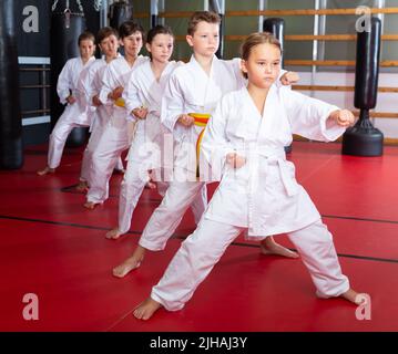 Karate Kids im Kimono, die Kata Moves ausführen Stockfoto