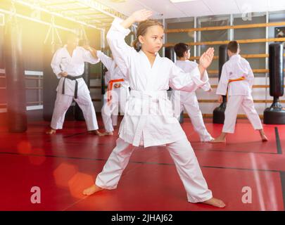 Mädchen kämpfen Karate stehen in der Turnhalle. Kinder zu zweit üben Karate Stockfoto