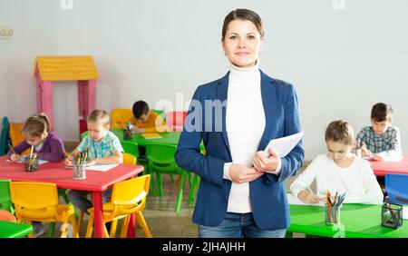 Lehrer im Klassenzimmer stehen lächelnd Stockfoto