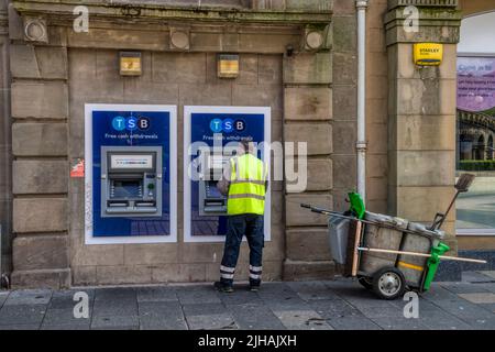 Ein Straßenreiniger mit einem TSB-Geldautomat in Dundee. Stockfoto