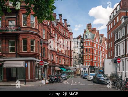 London, Großbritannien - 14. Juli 2022: Reihe von hohen, gehobenen Wohngebäuden aus rotem Backstein in Kensington, London Stockfoto