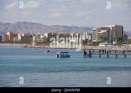 Aqaba, Jordanien - 14. März 2014: Menschen auf dem Pier gegen den Yachthafen und neue Hotels von North Beach Stockfoto