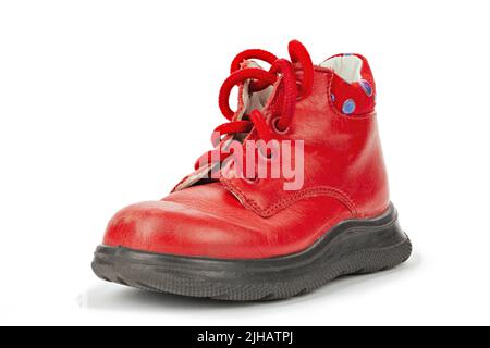 Abgenutzte rote Schnürsenkel im Kinderformat. Kinderschuhe mit Schnürsenkeln. Alte Stiefeletten für kleine Kinder. Datei enthält Beschneidungspfad. Stockfoto