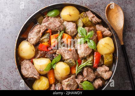 Leckeres Peka-Fleisch und -Gemüse im traditionellen Balkan, serbische, bosnische Gerichte aus nächster Nähe auf dem Tisch. Horizontale Ansicht von oben Stockfoto