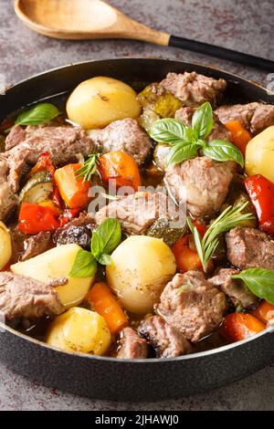 Köstliche kroatische Peka aus Kalbsfleisch mit saisonalem Gemüse und Kräutern aus der Nähe auf dem Tisch gekocht. Vertikal Stockfoto