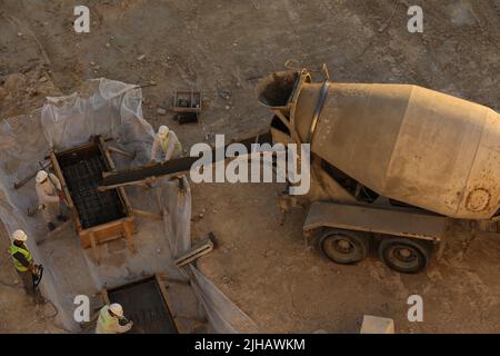 Mischer LKW ist Zement zu gießen frischen Beton in ein Fundament in der Wohnentwicklung Stockfoto