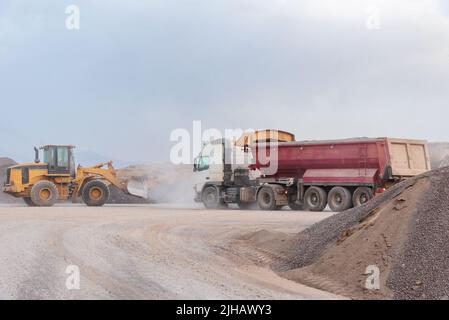 Baggerschaufel beim Laden eines Muldenkipper in einem Steinbruch Stockfoto