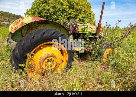 Ein rostiger alter John Deere Traktor auf einem Feld in Südfrankreich Stockfoto